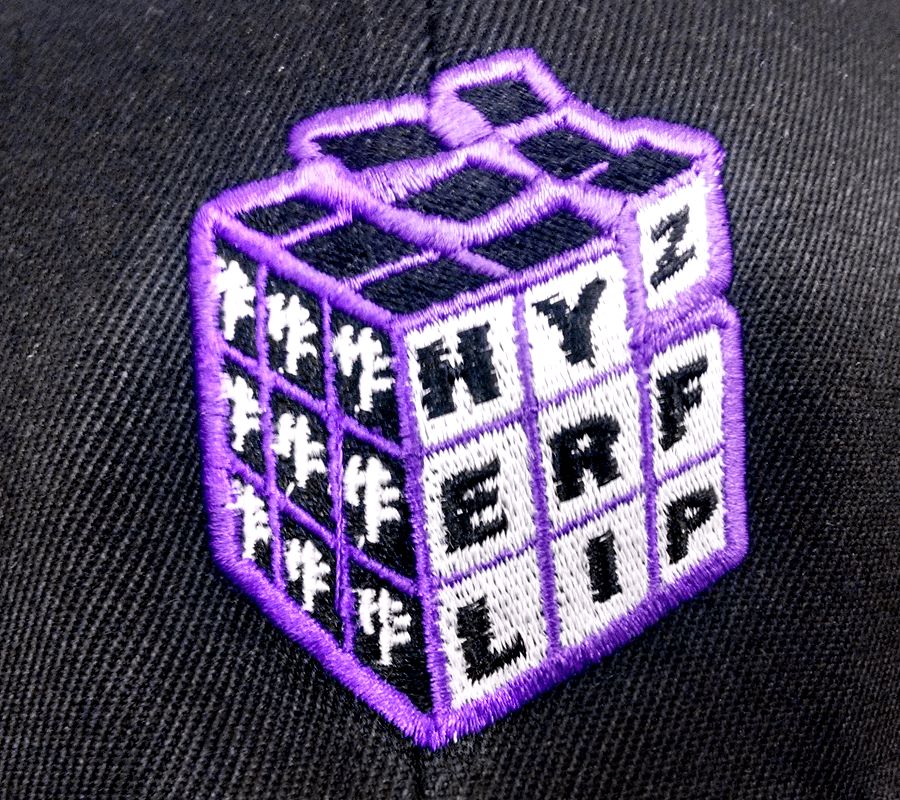 A purple and black hat with a rubix cube on it